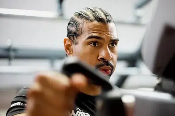 black-man-with-beard-and braids-on-a-cross-trainer-breathing-heavily