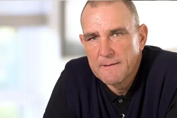 a-man-with-a-shaved-head-wearing-a-dark-jumper-looks-directly-into-the-camera