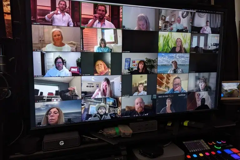 large-monitor-showing-20-virtual-people-live-streaming-a-live-event-people-look-various-levels-of-engagement